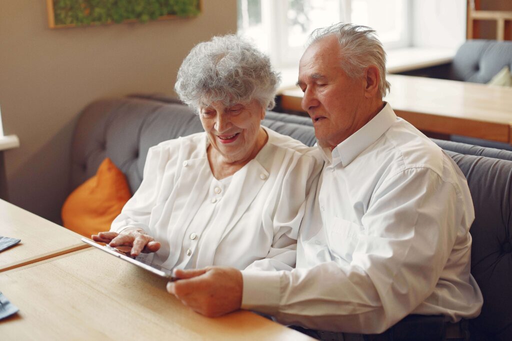 Dos personas mayores aprendiendo a usar una tablet