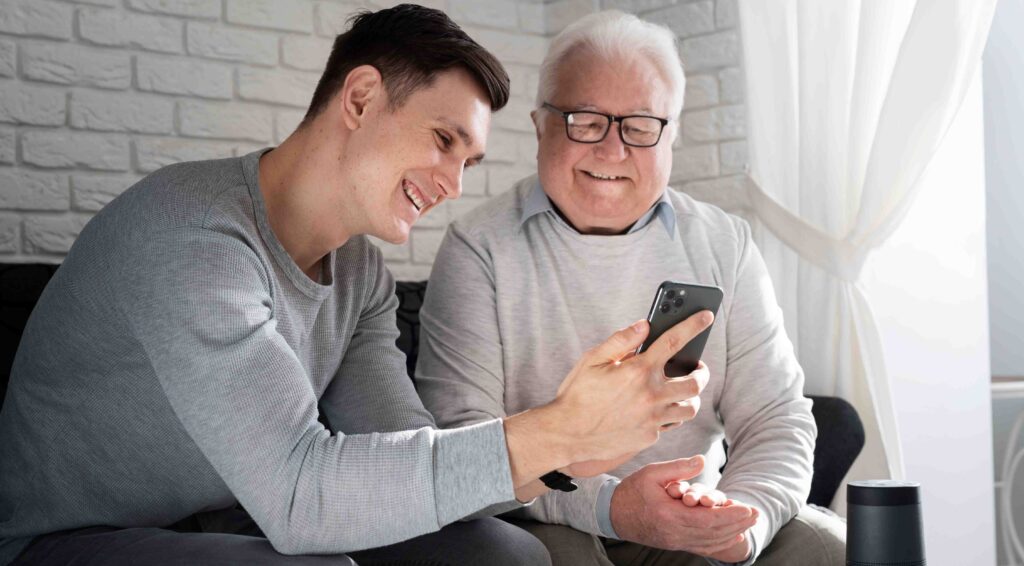 Nieto le enseña a persona mayor a usar tecnología móvil