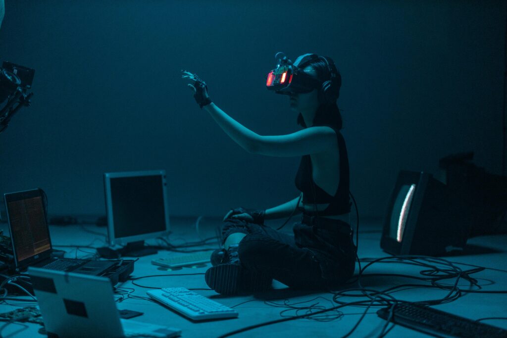 Mujer sentada delante de pantallas usando unas gafas de realidad virtual